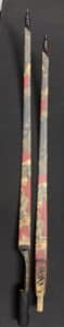 Two ornate chopsticks with red and gold decorative patterns.