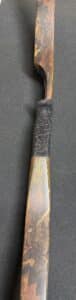 Close-up of a knife handle with textured grip and brass bolster.