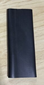 Black leather wallet on a wooden surface.