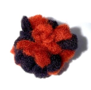 A red and black fuzzy scrunchie on a white background.