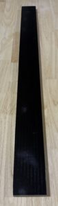 A black smartphone on a wooden surface.