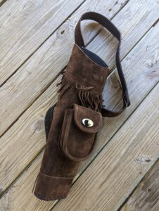 Brown suede fringe shoulder bag with a front pocket and strap.