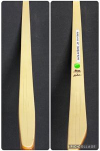 Two views of a wooden cricket bat with branding and signature.