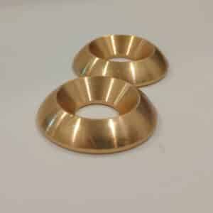 Two metallic, gold-colored, round objects with central holes.