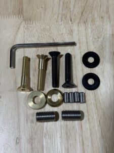 Various screws, nuts, spacers, and an Allen wrench arranged on a surface.