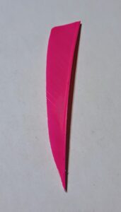 Close-up of a bright pink knife blade on a white background.