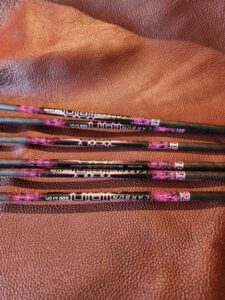 Close-up of colorful pencils with floral designs on a textured surface.