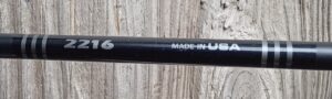 Close-up of a black object labeled 'MADE IN U' against a textured background.
