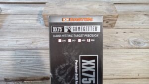 XX75 Hard Hitting Target Precision ammo box with wooden background.