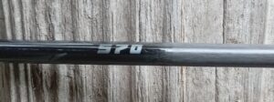 Close-up of a black object with '570' printed in white on a wooden surface.