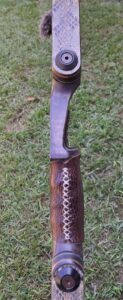 Close-up of a rustic knife handle with decorative leather wrapping.