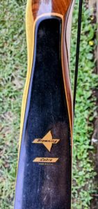 Close-up of a black and wooden Izanagi branded item outdoors.