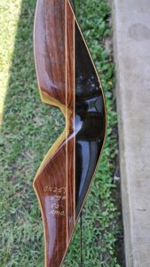 Close-up of a wooden recurve bow with detailed grain and string.