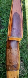 Close-up of a vintage wooden rifle stock with intricate details.