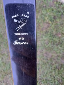 Close-up of a brown wooden bow with white text and graphics.