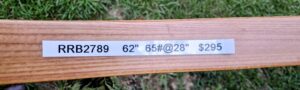 A wooden board with a tape measure showing measurements and markings.