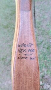 Wooden bow with handwritten specifications on it.