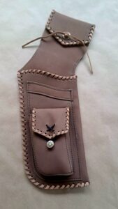 Handcrafted leather pouch with intricate stitching and a decorative button.
