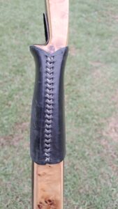 Close-up of a laced black leather handle grip.