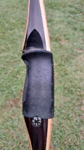 Close-up of a worn-out black shoe sole on grass.