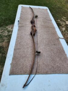 Long dog leash stretched on a carpet with a dog in the middle.