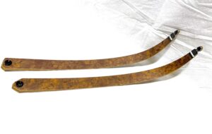 Two rustic wooden curved sticks on a white surface.
