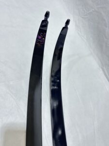 Two black curved archery limbs on a white surface.
