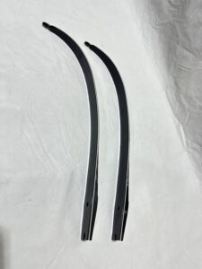 Two curved black windshield wipers on a white cloth.