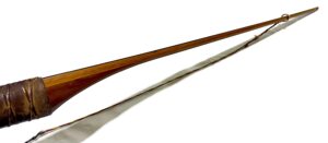 Two long wooden sticks, one brown and one white, placed side by side.