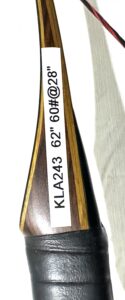 Close-up of a wooden paddle with engraved coordinates and code.