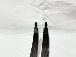 Two black metallic combs with handles on a white surface.