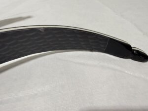 Close-up of a black hockey stick blade on a white surface.