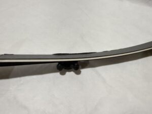 A curved sword with a black handle on a white surface.