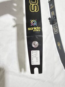 Close-up of a black archery stabilizer with colorful logo and label.