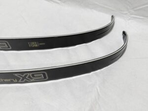 Two black archery bow limbs with branding on a white fabric background.