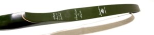 Close-up of a surfboard with handwritten signatures on a green section.