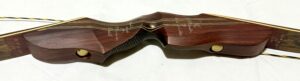 Close-up of a wooden stringed musical instrument's curved body and strings.