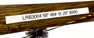 A fishing lure with detailed specifications printed on its wooden body.