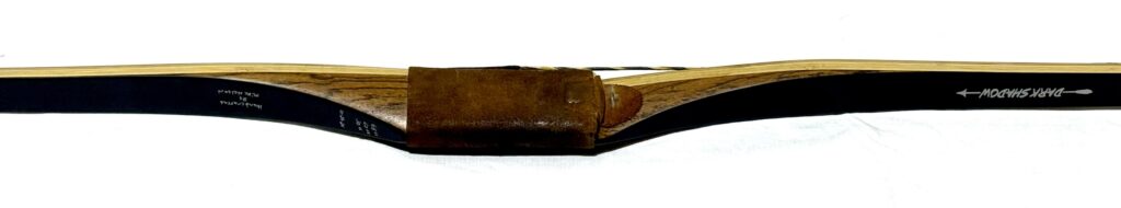 A brown leather sheath partially covering a wooden knife handle.