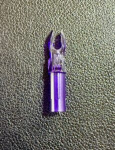 Purple metallic connector on textured surface.
