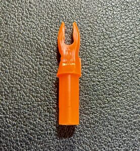 Orange arrow nock on a textured black surface.