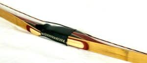 A close-up of a classic wooden fountain pen with a gold nib.