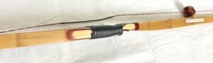 Close-up of a fishing rod handle with black grip and copper reel seat.